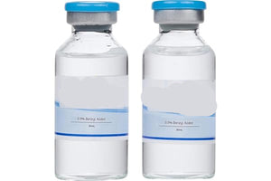Two vials of reconstitution solution with blue caps on a white background