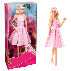 Barbie doll in pink dress with matching box on a white background