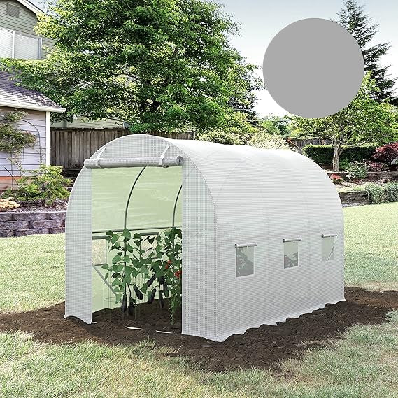 White greenhouse with plants inside, set against a natural outdoor background.