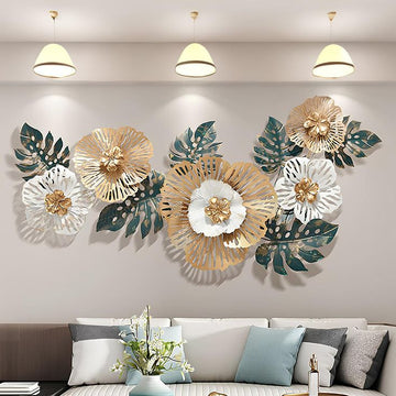 Decorative wall art with floral and leaf designs on a wall above a sofa.